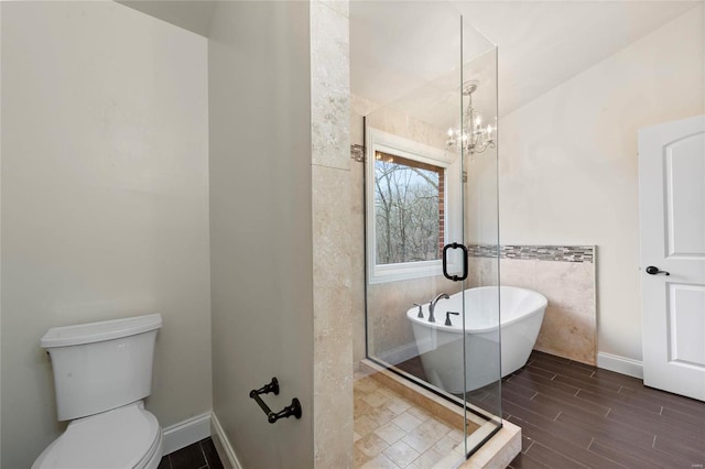 bathroom featuring a bath, tile walls, a chandelier, and toilet