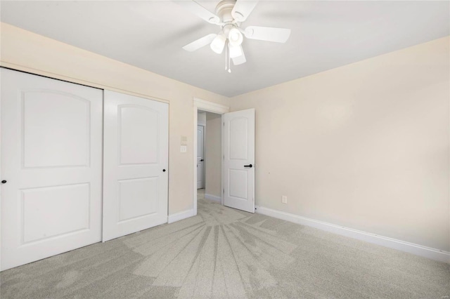 unfurnished bedroom featuring light carpet, ceiling fan, and a closet