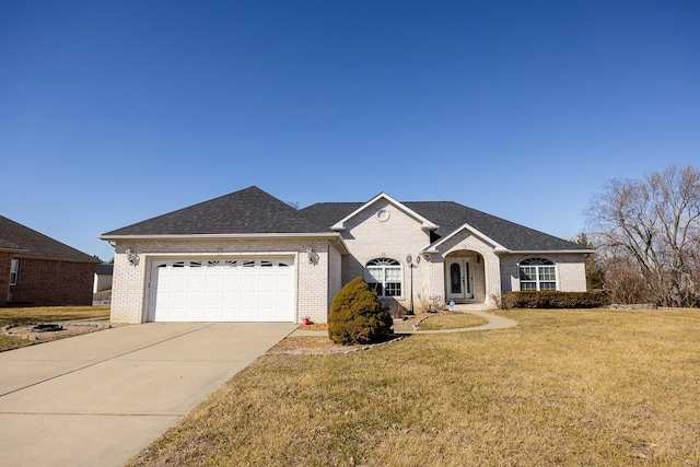 view of front of house with driveway, a front lawn, an attached garage, and brick siding