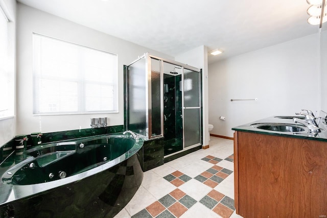 full bathroom featuring toilet, vanity, baseboards, a whirlpool tub, and a stall shower