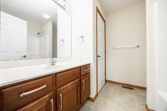 bathroom with a shower, visible vents, vanity, tile patterned flooring, and baseboards