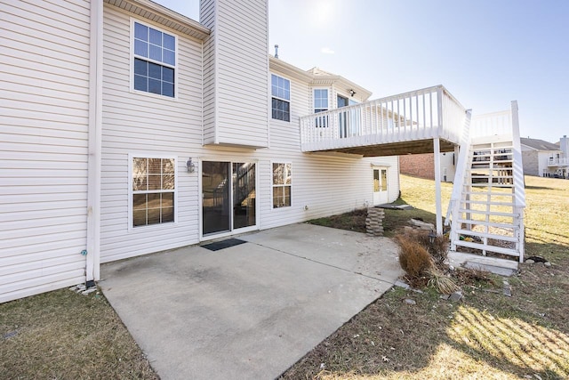 back of property featuring stairway, a patio, a chimney, and a deck