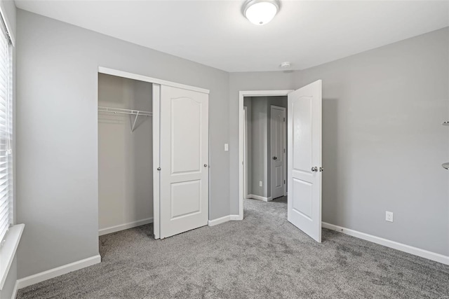 unfurnished bedroom featuring light colored carpet and a closet