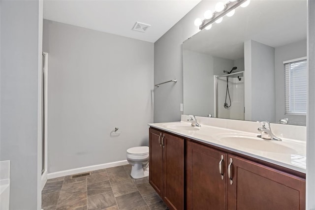 bathroom featuring a shower with door, vanity, and toilet