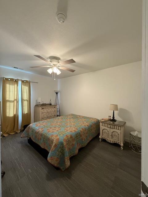 bedroom with dark wood-type flooring and ceiling fan