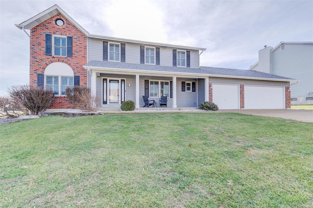 front of property with a garage, covered porch, and a front lawn