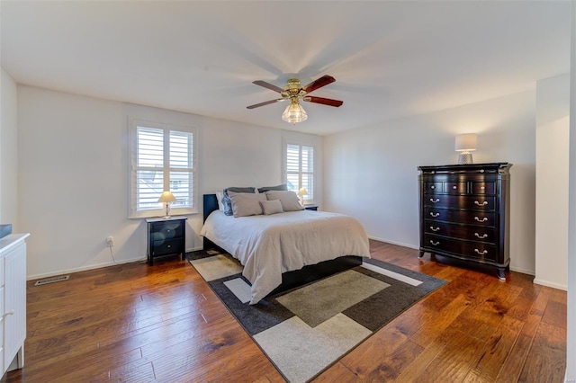 bedroom with dark hardwood / wood-style flooring and ceiling fan