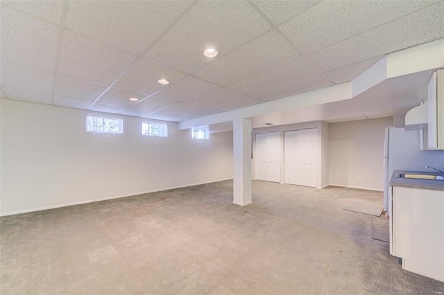 basement with carpet floors and a drop ceiling