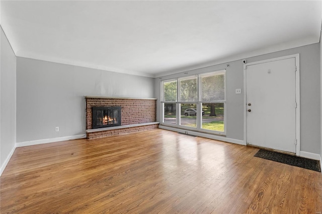 unfurnished living room featuring a fireplace and light hardwood / wood-style floors