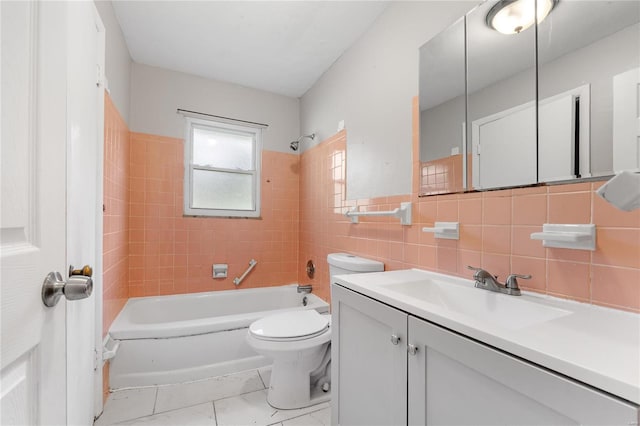 full bathroom with tiled shower / bath, tile walls, vanity, and toilet