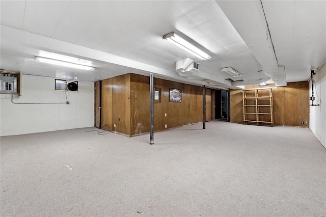 basement with electric panel and wood walls