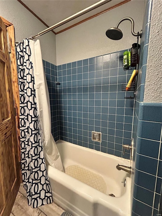 bathroom with crown molding and shower / tub combo with curtain