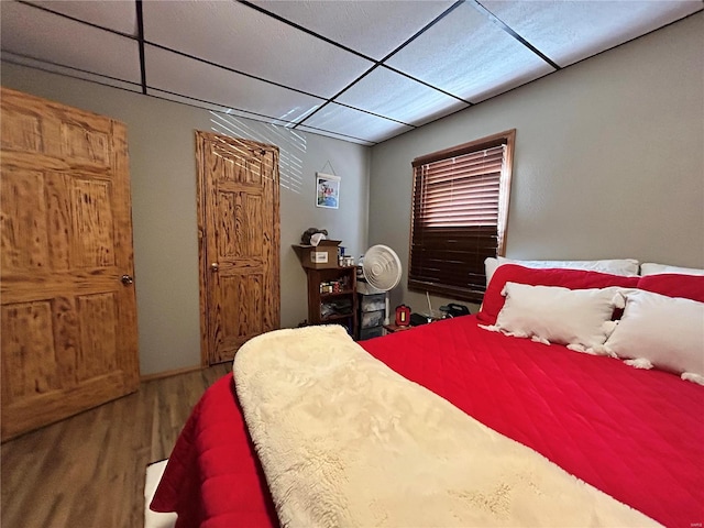 bedroom featuring a paneled ceiling and wood-type flooring