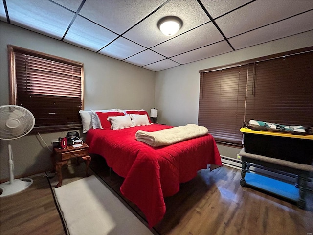 bedroom with wood-type flooring and a paneled ceiling