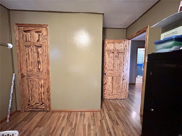 hall with hardwood / wood-style floors and crown molding