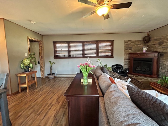 living room with a baseboard radiator, hardwood / wood-style floors, ceiling fan, and a fireplace