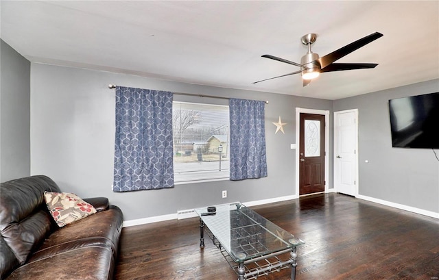 living room with dark wood-type flooring and ceiling fan