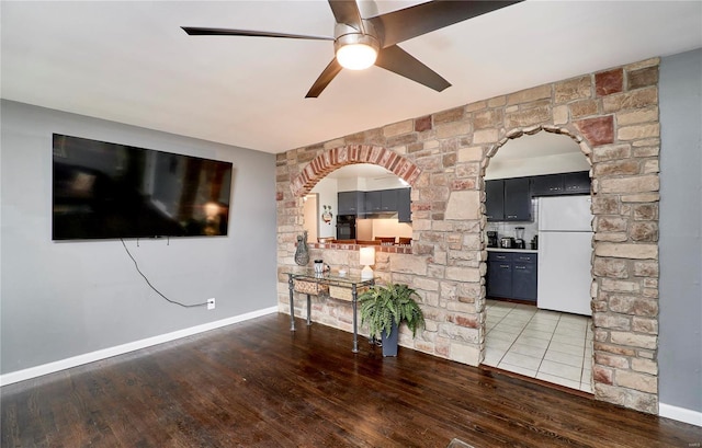 unfurnished living room with dark wood-type flooring and ceiling fan