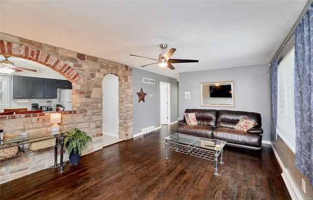 living room featuring dark wood-type flooring and ceiling fan