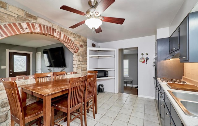 tiled dining area featuring ceiling fan and sink