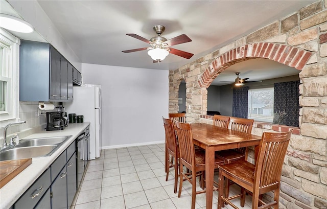 tiled dining room with ceiling fan and sink