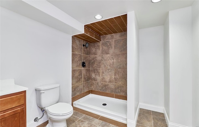 bathroom with vanity, tiled shower, and toilet