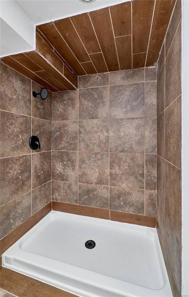 bathroom featuring wooden ceiling and a tile shower