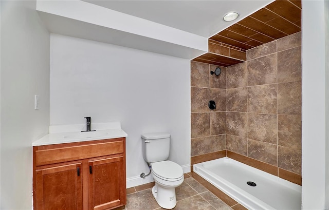 bathroom with tiled shower, vanity, toilet, and tile patterned flooring