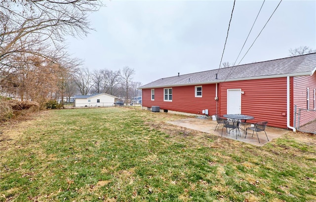 rear view of property with a lawn, a patio, and central air condition unit