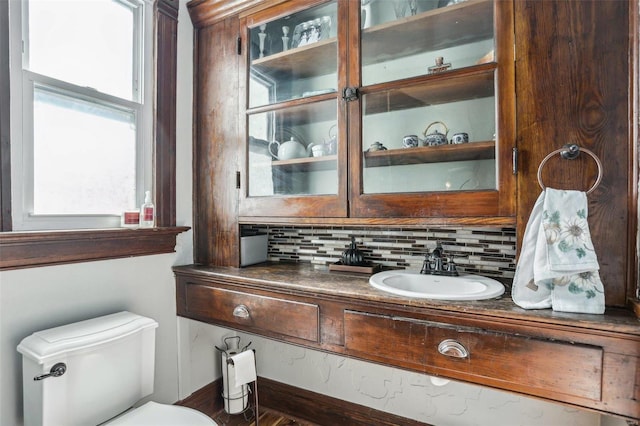 bathroom featuring tasteful backsplash, vanity, and toilet