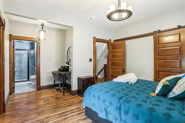 bedroom featuring dark hardwood / wood-style flooring, a closet, a barn door, and ensuite bathroom