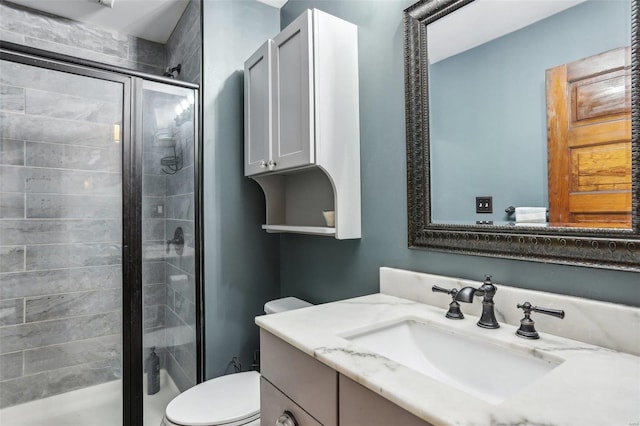 bathroom featuring vanity, toilet, and an enclosed shower