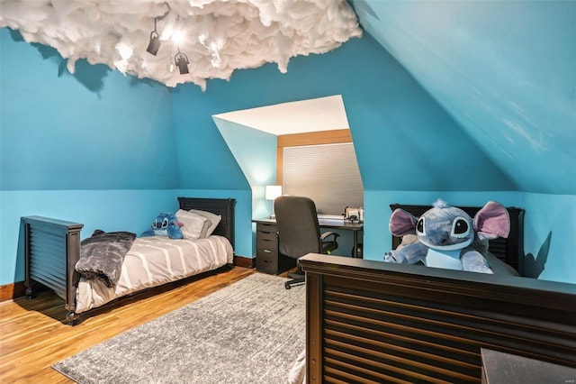 bedroom with hardwood / wood-style flooring and vaulted ceiling