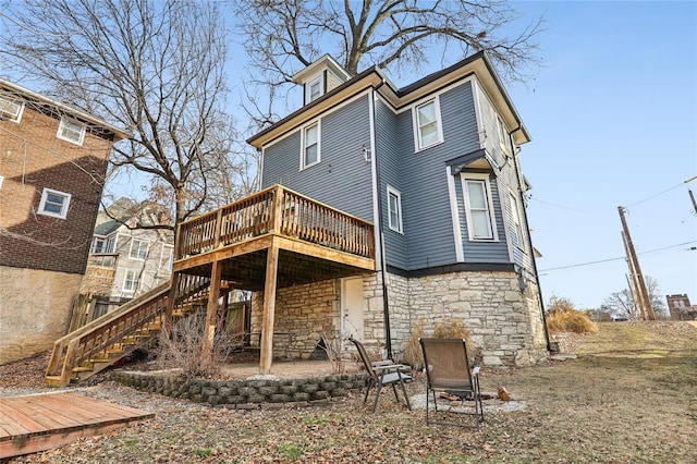 rear view of house with a wooden deck and a patio