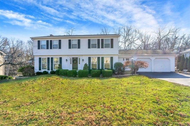 colonial inspired home featuring a garage and a front lawn