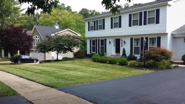 colonial house with a garage and a front yard