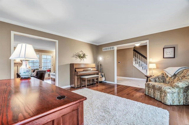 living room featuring french doors, ornamental molding, and wood-type flooring