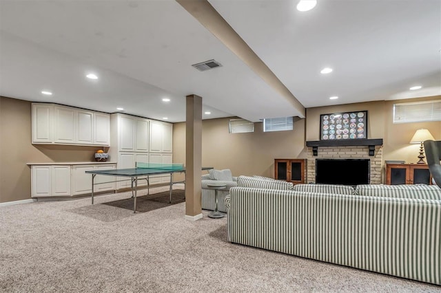 living room featuring a brick fireplace and light colored carpet