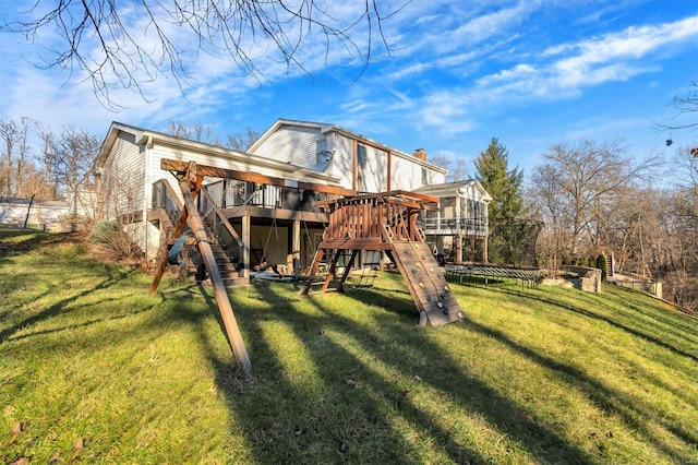 rear view of house featuring a yard and a playground