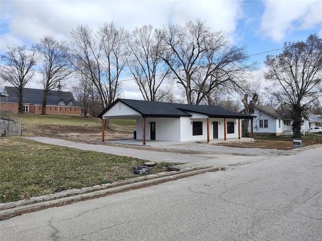 view of front facade featuring a carport and a front lawn