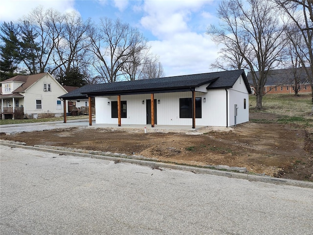 view of front of house with covered porch and a shingled roof