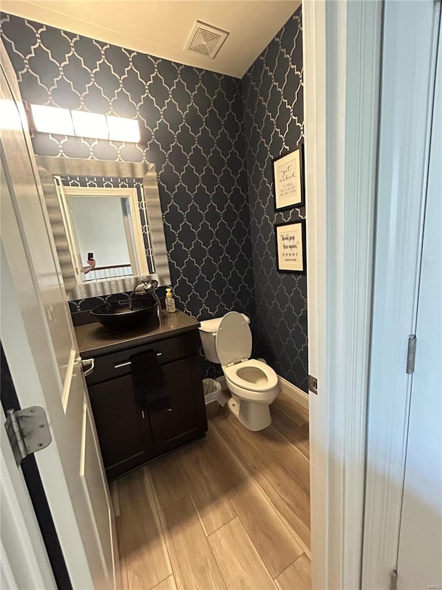 bathroom featuring vanity, hardwood / wood-style floors, and toilet