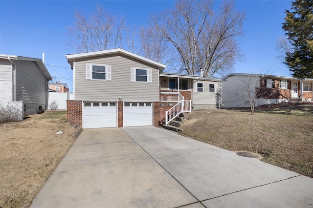 view of front of home with a garage, a front yard, and covered porch