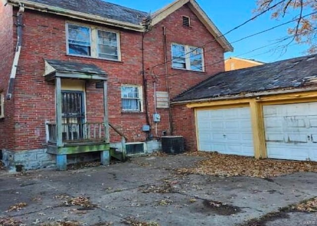 view of side of property featuring a garage and central AC