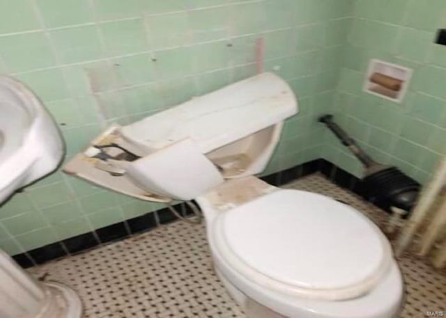 bathroom featuring tile walls, tile patterned floors, and toilet