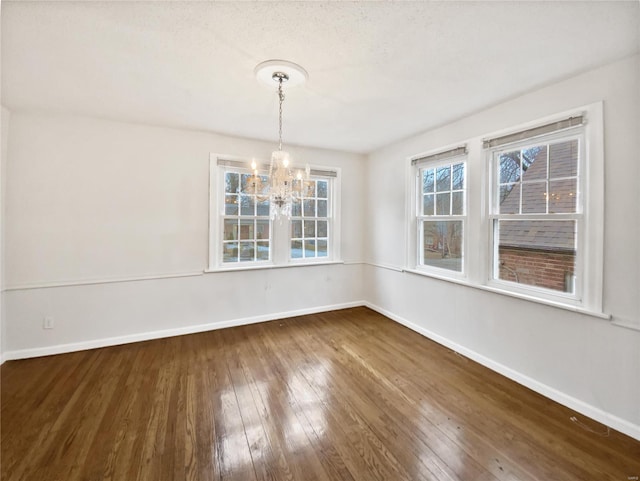 unfurnished dining area with an inviting chandelier and wood-type flooring