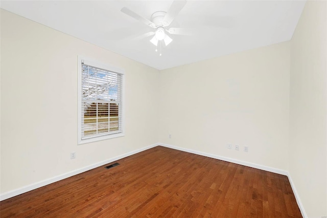 unfurnished room featuring a ceiling fan, wood finished floors, visible vents, and baseboards