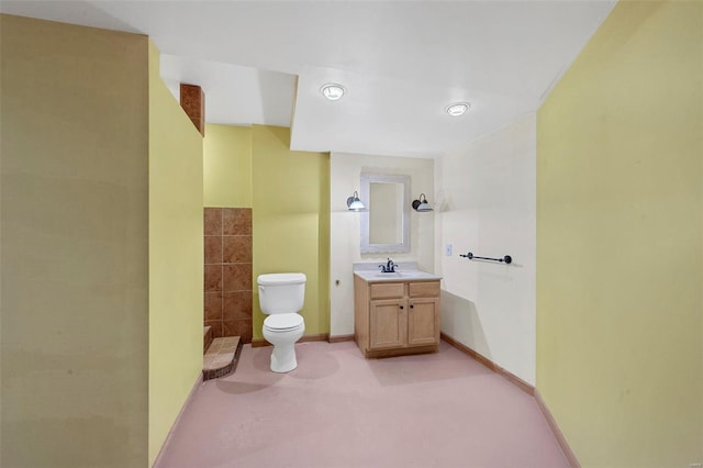 bathroom featuring vanity, toilet, and baseboards