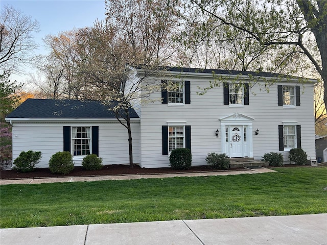 colonial home featuring a front lawn