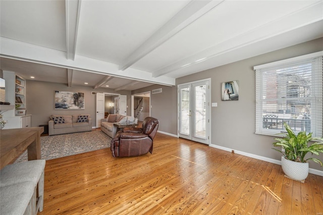 living room featuring french doors, beam ceiling, and light hardwood / wood-style flooring